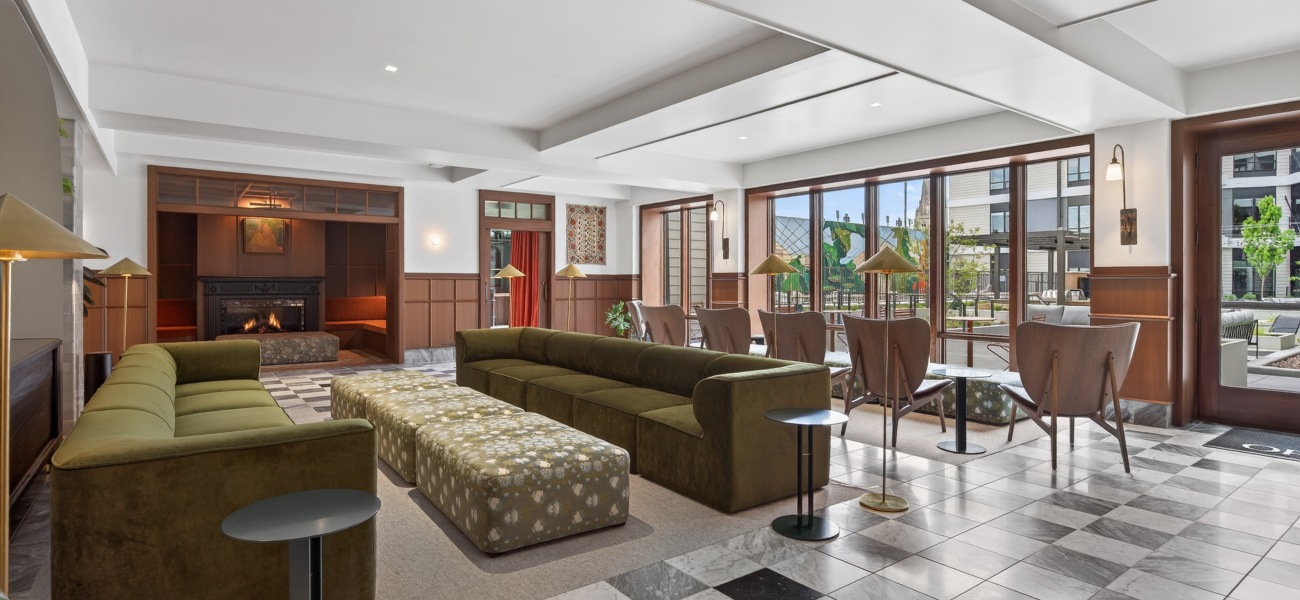 lounge with green sofas and view of outdoor courtyard